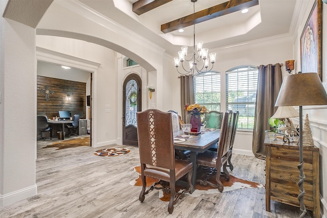 dining space featuring light hardwood / wood-style floors, ornamental molding, and a chandelier