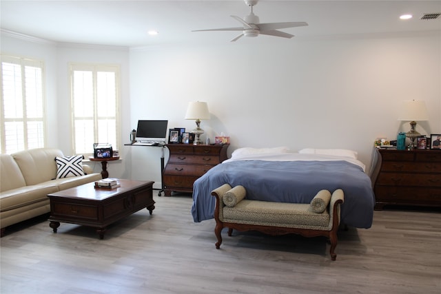 bedroom featuring ceiling fan, ornamental molding, and light hardwood / wood-style floors