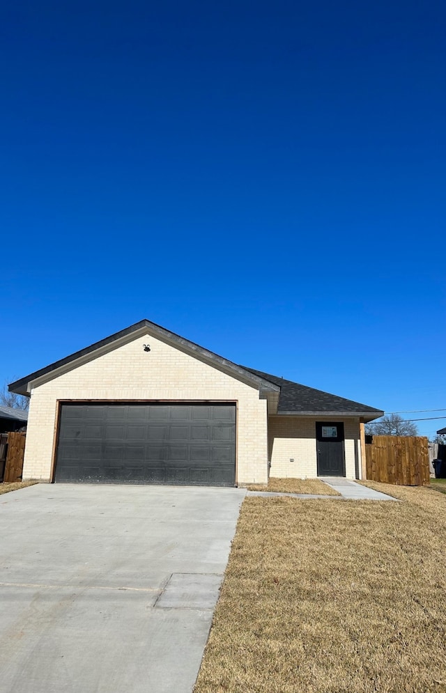 ranch-style house featuring a garage and a front yard