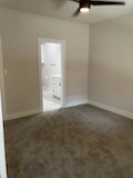 unfurnished room featuring ceiling fan and carpet flooring