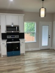 kitchen with appliances with stainless steel finishes, light hardwood / wood-style floors, and white cabinetry