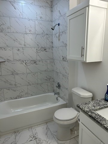 full bathroom featuring tiled shower / bath combo, vanity, and toilet