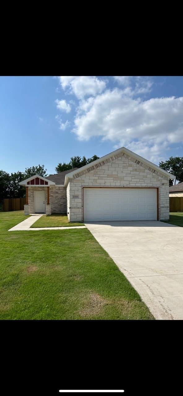 ranch-style house featuring a garage and a front lawn