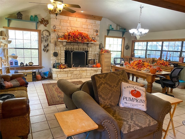 tiled living room featuring ceiling fan with notable chandelier, vaulted ceiling, and a stone fireplace