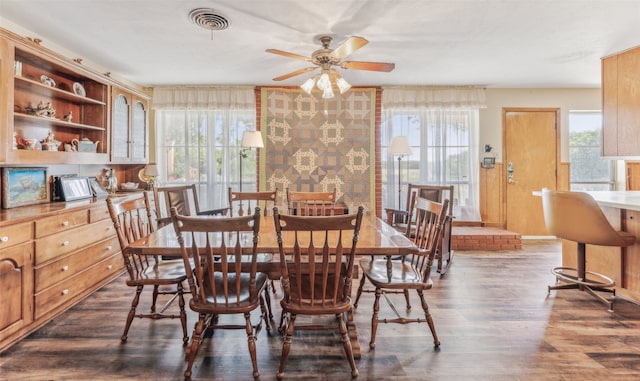 dining space with ceiling fan and dark wood-type flooring