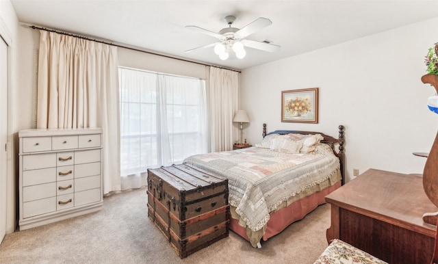 bedroom featuring ceiling fan, light colored carpet, and multiple windows