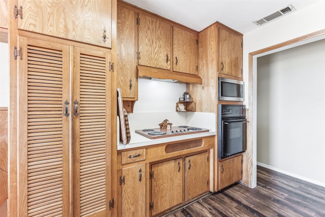 kitchen featuring stainless steel microwave, dark hardwood / wood-style flooring, white gas stovetop, and oven