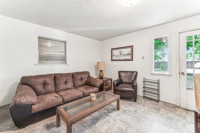 tiled living room featuring a textured ceiling