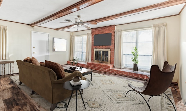 living room featuring ceiling fan, a fireplace, crown molding, and hardwood / wood-style flooring