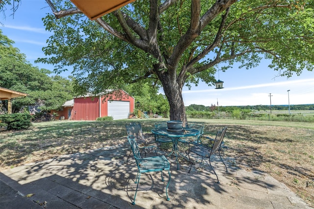 view of patio with an outbuilding and a garage