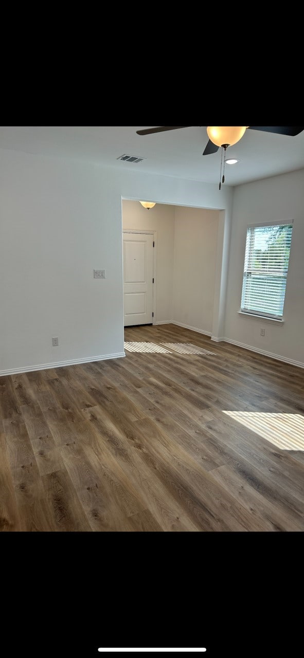 empty room featuring ceiling fan and dark hardwood / wood-style flooring