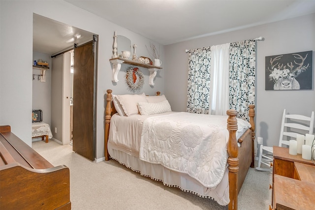 bedroom featuring a barn door and light colored carpet