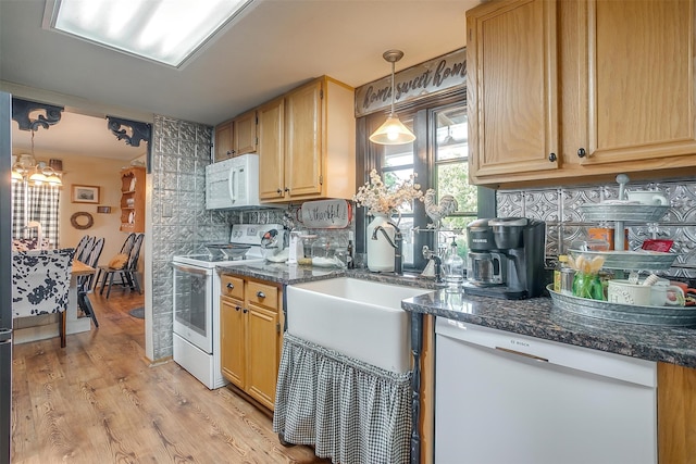 kitchen featuring tasteful backsplash, white appliances, hanging light fixtures, and light hardwood / wood-style floors