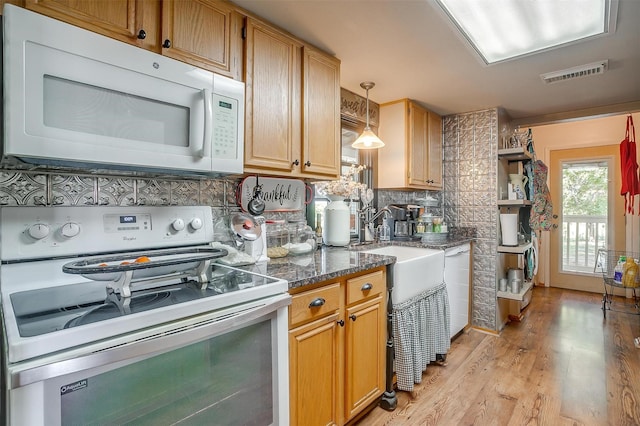 8716 County Road 1224a, Rio Vista, TX 76093 - kitchen with white appliances, light wood finished floors, visible vents, decorative backsplash, and decorative light fixtures