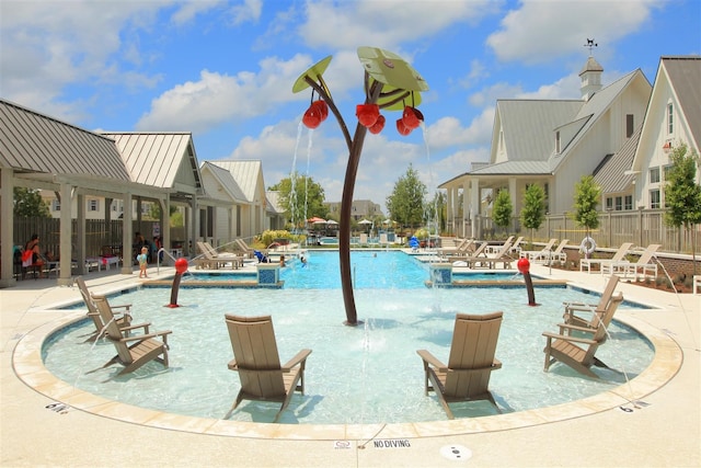 view of swimming pool with pool water feature and a patio area