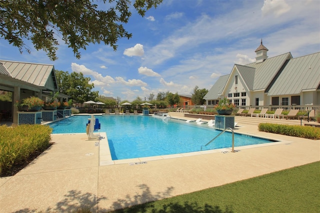 view of swimming pool featuring central air condition unit and a patio area