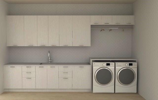 laundry area featuring cabinet space, washer and dryer, light wood-style flooring, and a sink