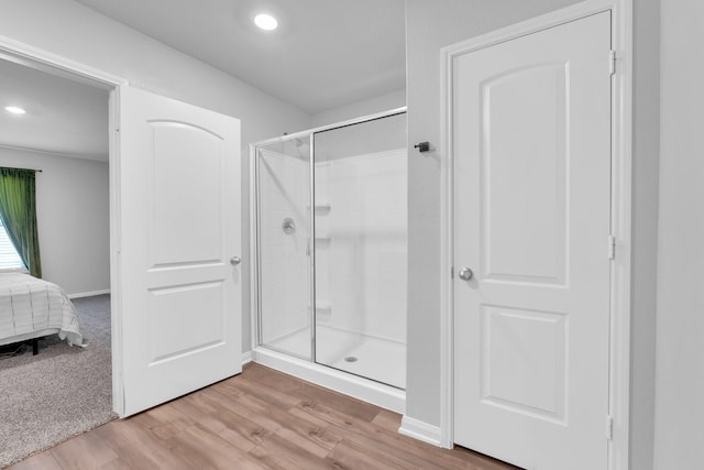 bathroom featuring hardwood / wood-style flooring and walk in shower