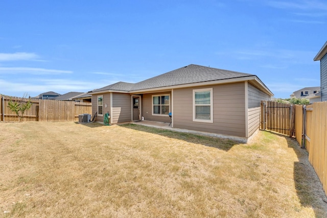 rear view of house featuring central AC unit and a lawn