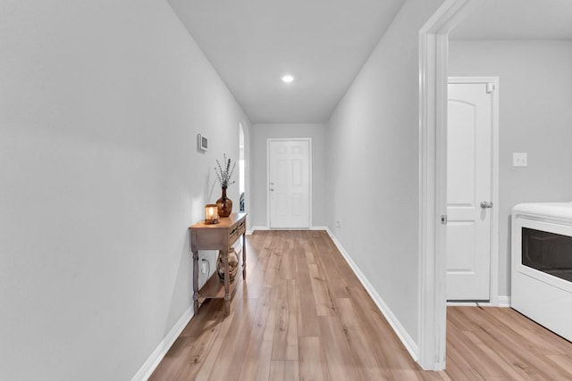 doorway with washer / clothes dryer and light hardwood / wood-style floors