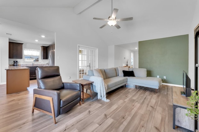 living room with light hardwood / wood-style floors, high vaulted ceiling, beamed ceiling, and ceiling fan