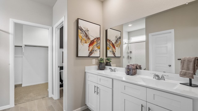 bathroom with double sink vanity, a shower with door, and wood-type flooring