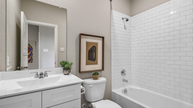 full bathroom with vanity, tiled shower / bath combo, and toilet