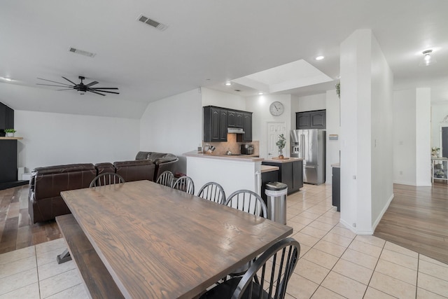 dining area featuring light tile patterned floors, visible vents, and a ceiling fan