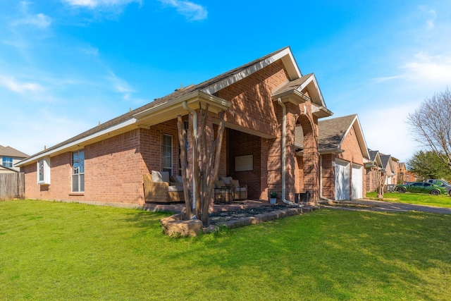 rear view of house featuring a garage, brick siding, a lawn, and aphalt driveway