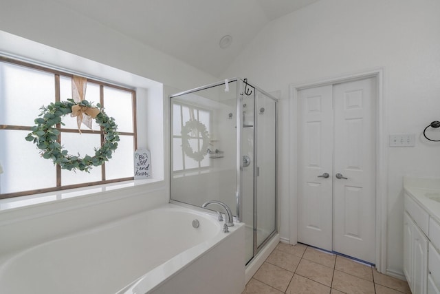 bathroom featuring lofted ceiling, a stall shower, vanity, a bath, and tile patterned floors