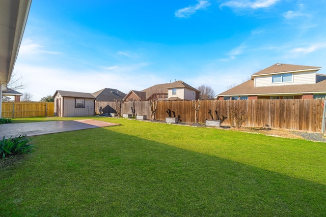 view of yard featuring an outbuilding, a shed, a patio area, and a fenced backyard