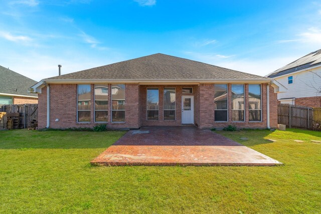 rear view of house featuring brick siding, a patio, and fence