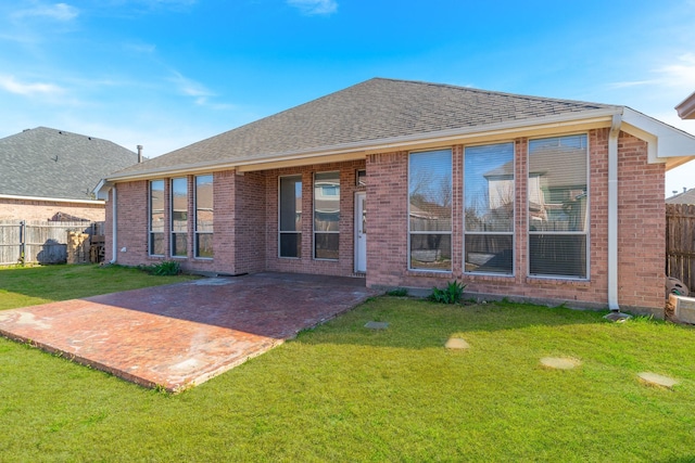 rear view of property with a yard, brick siding, and fence