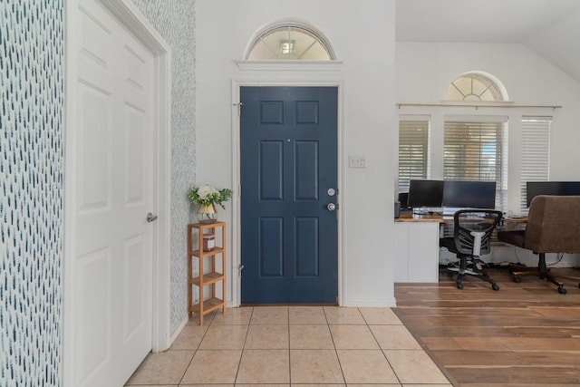 entrance foyer featuring lofted ceiling and light tile patterned floors