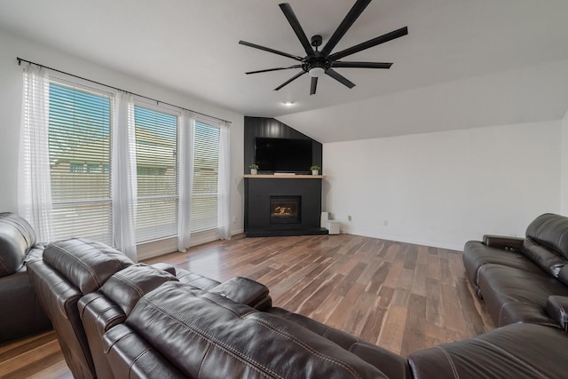 living room with baseboards, a ceiling fan, wood finished floors, vaulted ceiling, and a fireplace