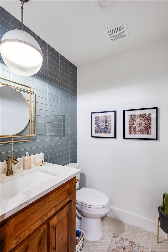 bathroom featuring vanity, tile walls, toilet, and tile patterned floors