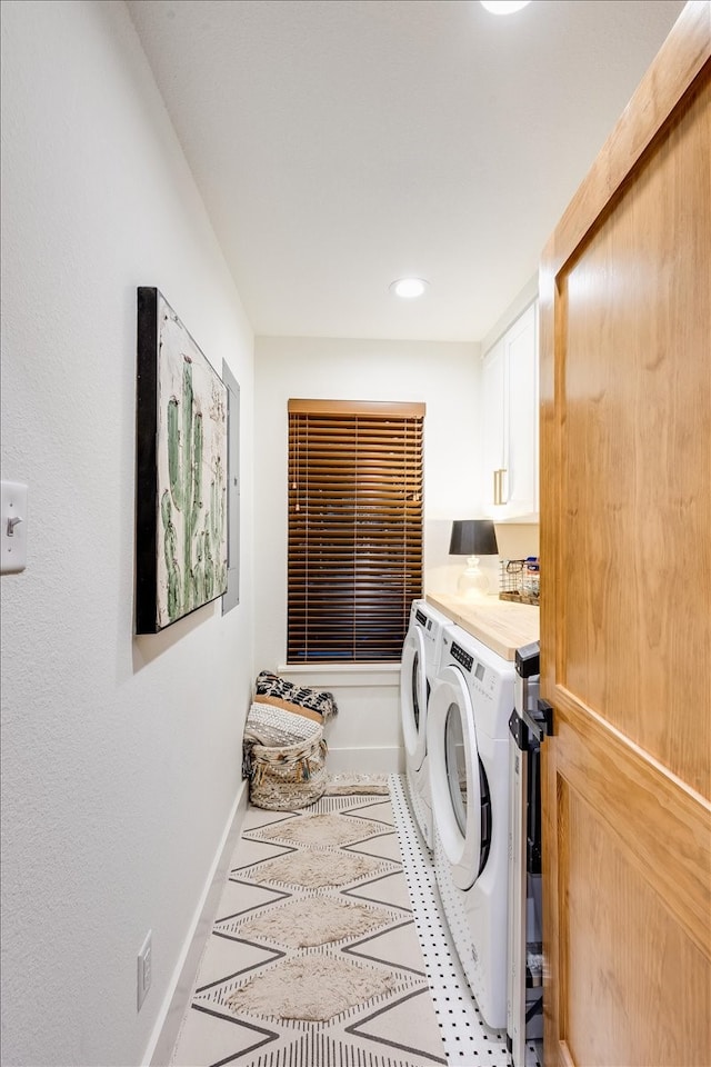 clothes washing area with independent washer and dryer and cabinets