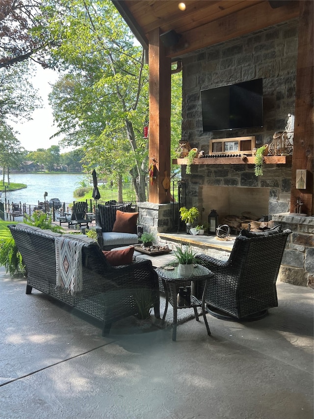 view of patio / terrace featuring an outdoor living space with a fireplace and a water view