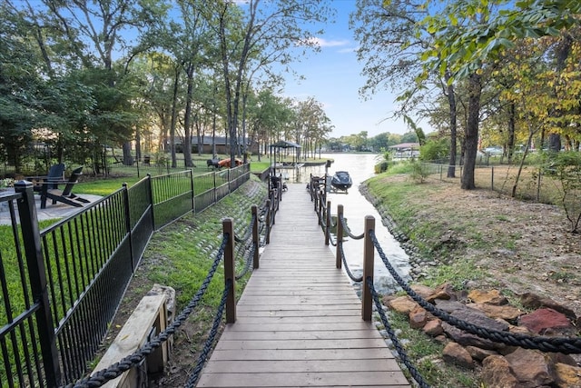 dock area with a water view and a lawn