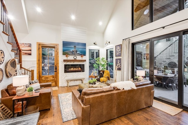 living room with hardwood / wood-style floors and high vaulted ceiling