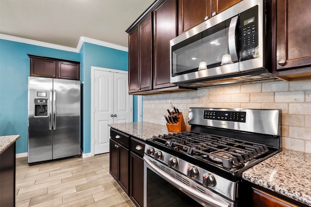 kitchen featuring tasteful backsplash, crown molding, dark brown cabinets, appliances with stainless steel finishes, and light stone counters