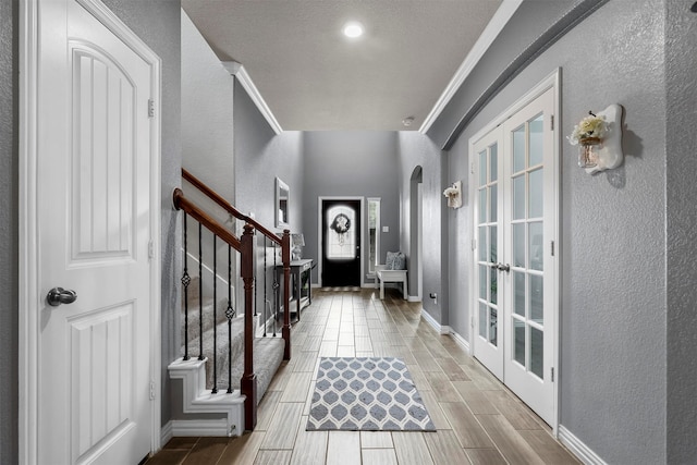 interior space featuring french doors, ornamental molding, and light hardwood / wood-style floors