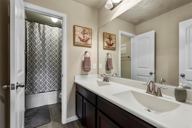 full bathroom with shower / bath combo with shower curtain, double sink vanity, toilet, and hardwood / wood-style flooring