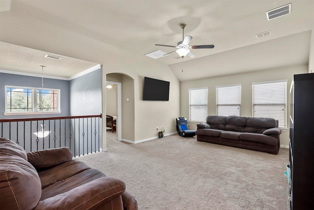 carpeted living room with ceiling fan, crown molding, and lofted ceiling