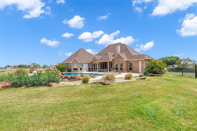 back of house with a fenced in pool and a yard