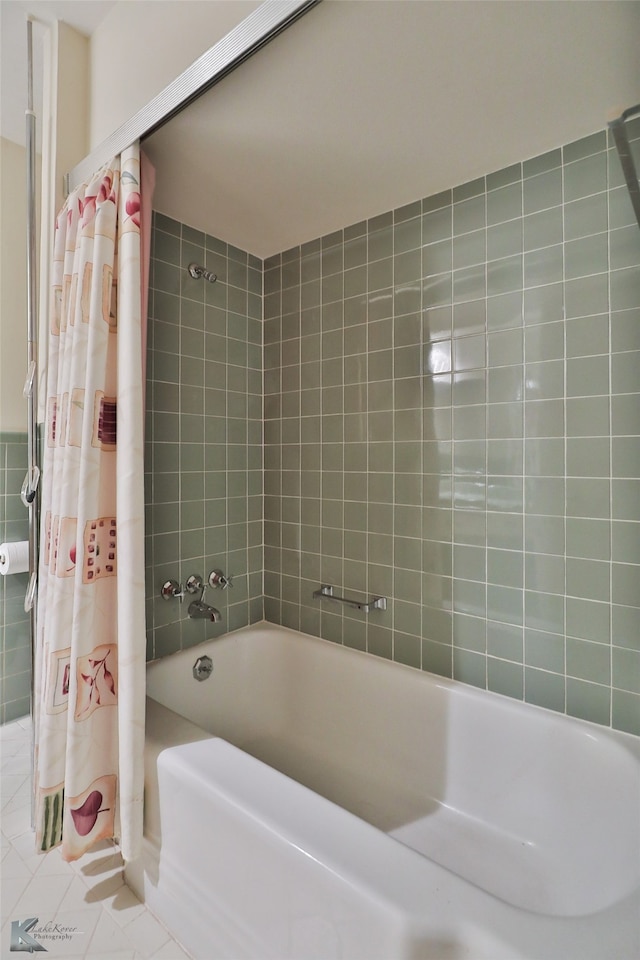 bathroom with shower / bath combo with shower curtain and tile patterned flooring