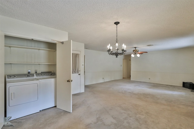 unfurnished dining area with ceiling fan with notable chandelier, a textured ceiling, and washing machine and dryer