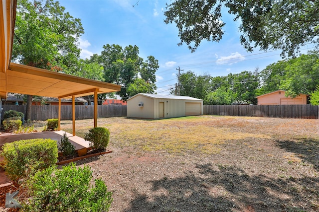 view of yard featuring a garage and an outbuilding