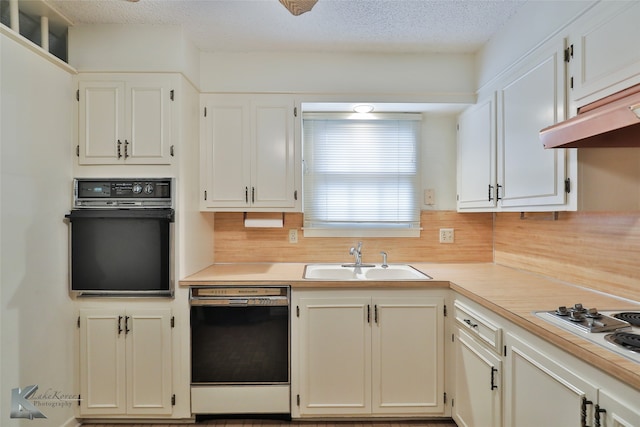 kitchen featuring decorative backsplash, a textured ceiling, white cabinets, black appliances, and sink