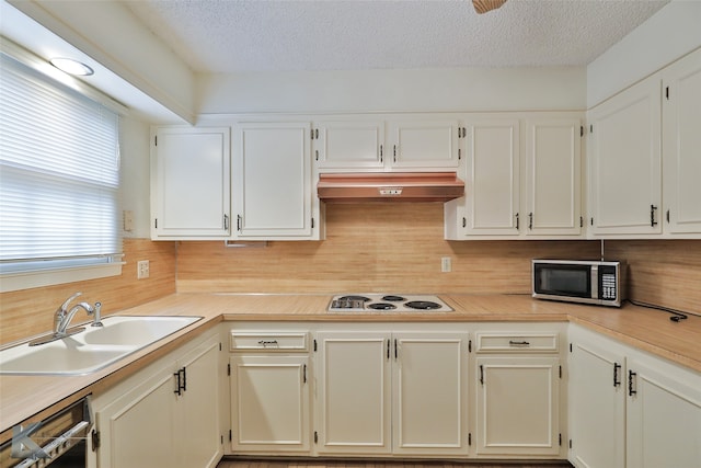 kitchen featuring decorative backsplash, black dishwasher, white gas cooktop, premium range hood, and sink